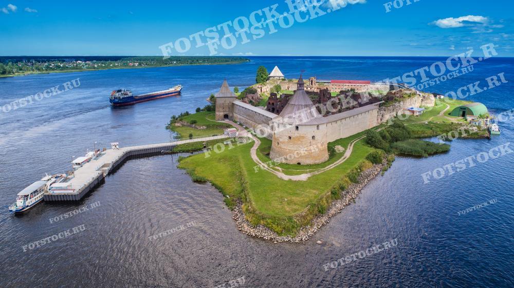 На фотографии изображена Крепость Орешек на острове в устье реки Невы. Это знаменитый исторический памятник, окружённый водами Невы. Крепостные стены и башни выстроены из кирпича, что подчёркивает их древнюю историю. 
Фотография может быть использована в исторических книгах, туристических гидах, а также в образовательных целях.